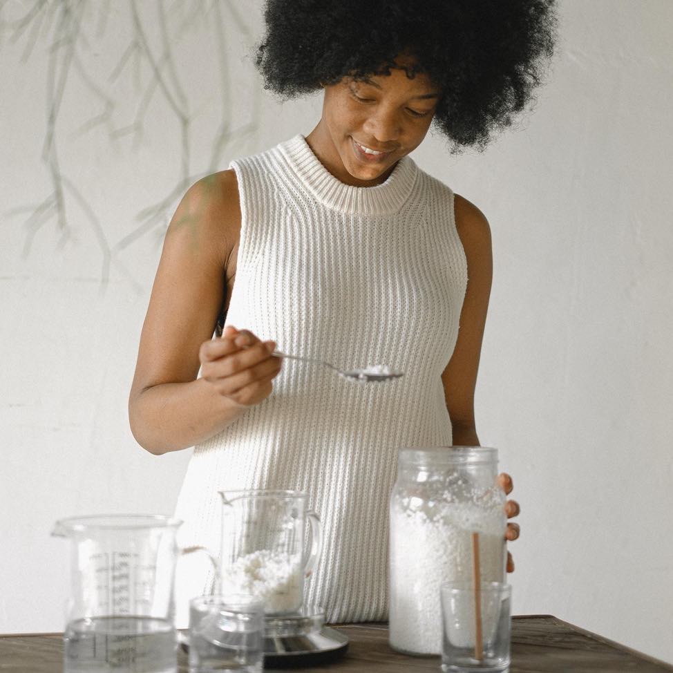 Woman measuring out sea moss into a cup. 